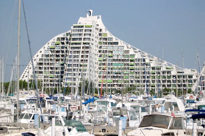 La Grande Pyramide de La Grande-Motte, en gradins blancs, vue depuis le port et ses voiliers.